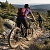 vététiste sur un VTT tout-suspendu en forêt, ambiance automnale